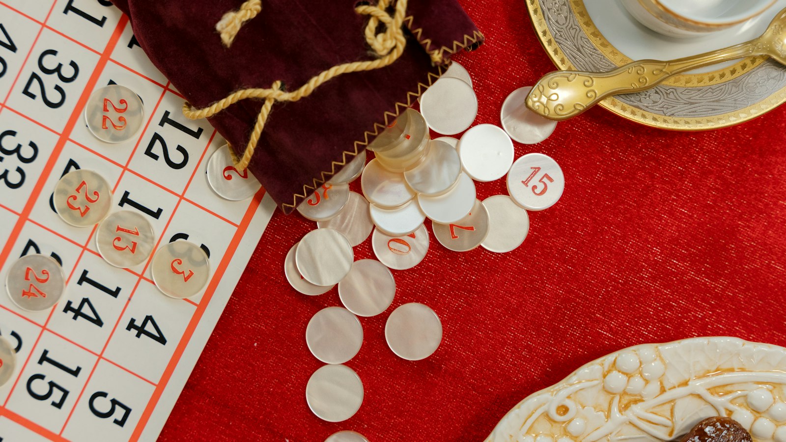 Cartones de bingo y fichas numeradas sobre un paño rojo