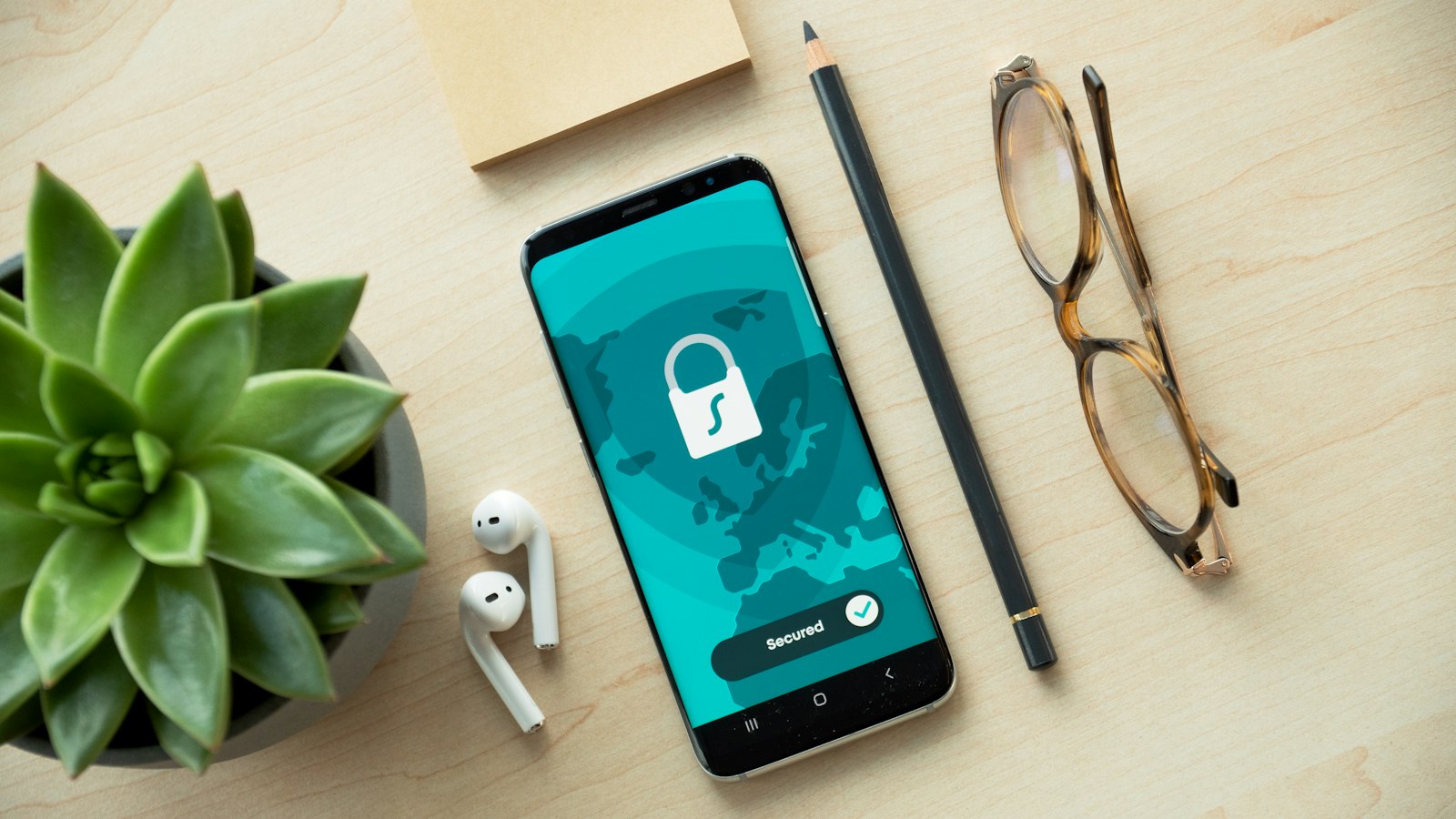 Celular con un candado de seguridad en pantalla sobre un escritorio